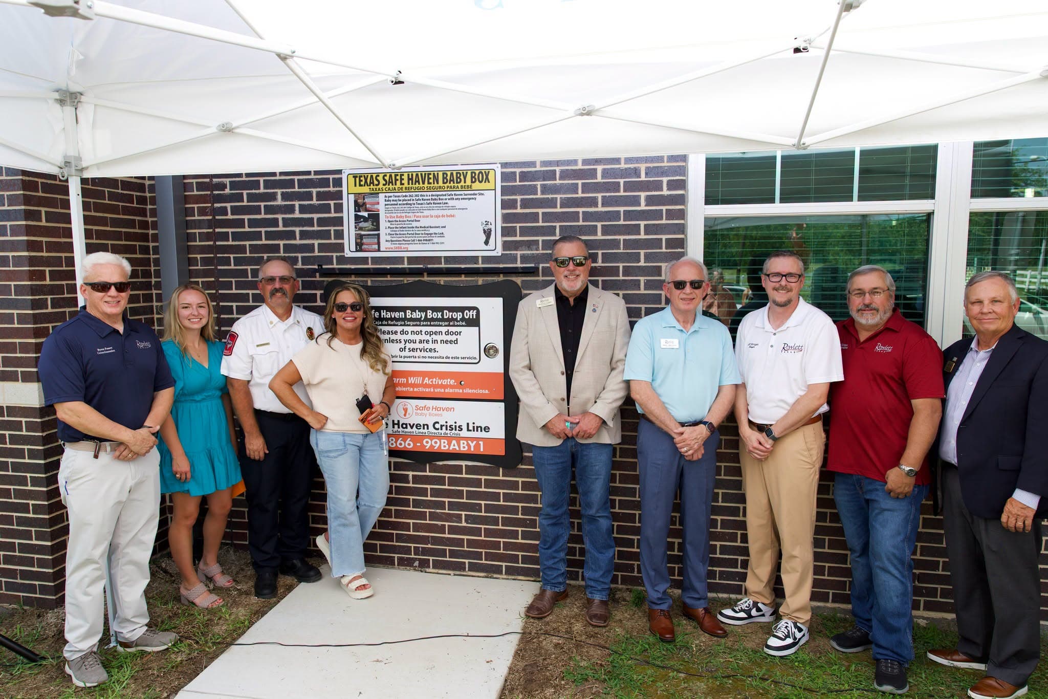 City of Rowlett leaders and firefighters standing beside the Texas Safe Haven Baby Box at Fire Station #1